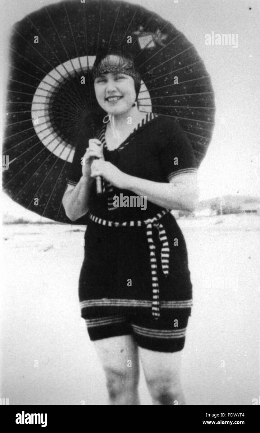 230 StateLibQld 1 148499 giovane donna in posa con un ombrellone sulla spiaggia, ca. 1925 Foto Stock
