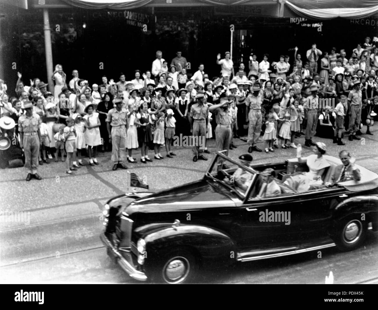 252 StateLibQld 1 213888 la Regina Elisabetta II e il Duca di Edimburgo viaggiare lungo Queen Street, Brisbane, l'ultimo giorno del loro tour del Queensland nel 1954 Foto Stock
