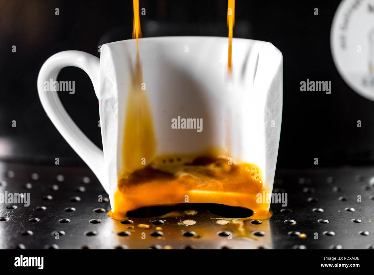 Caffè versato nel bicchiere rotto su un home macchina espresso. Concetto di bad mattina Foto Stock