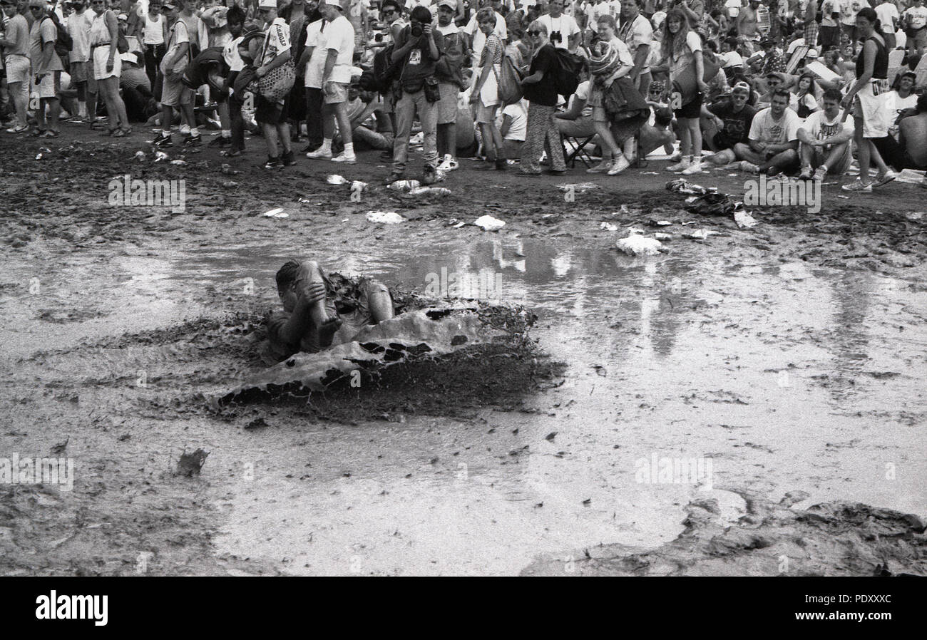 Giovane uomo adulto scorrevole nel fango durante Woodstock Music Festival, Saugerties, New York, USA, luglio 13, 1994 Foto Stock