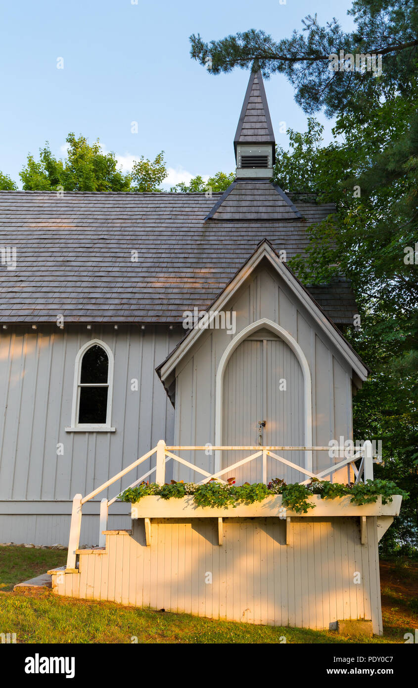 Una piccola chiesa rurale nei boschi, immerso nella luce del sole e ombra. Foto Stock