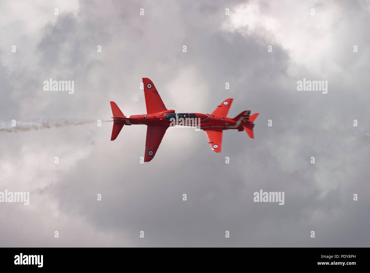 Due British Aerospace Hawk Jet militare dei formatori della Royal Air Force frecce rosse Aerobatic Team di visualizzazione eseguire una testa a testa croce oltre al RIAT Foto Stock