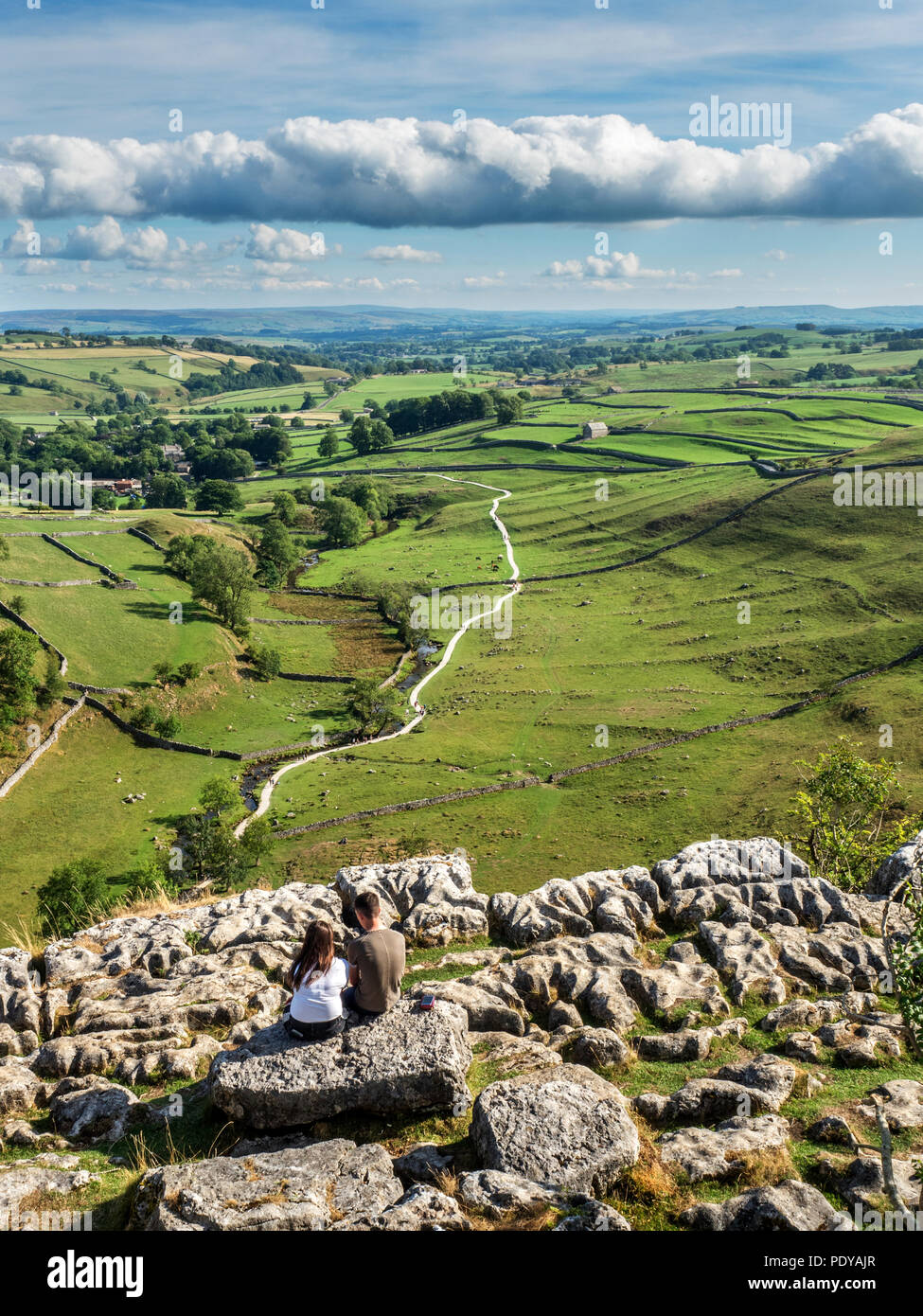 Coppia seduta ammirando la vista su malhamdale da Malham Cove vicino Malham Yorkshire Dales Inghilterra Foto Stock