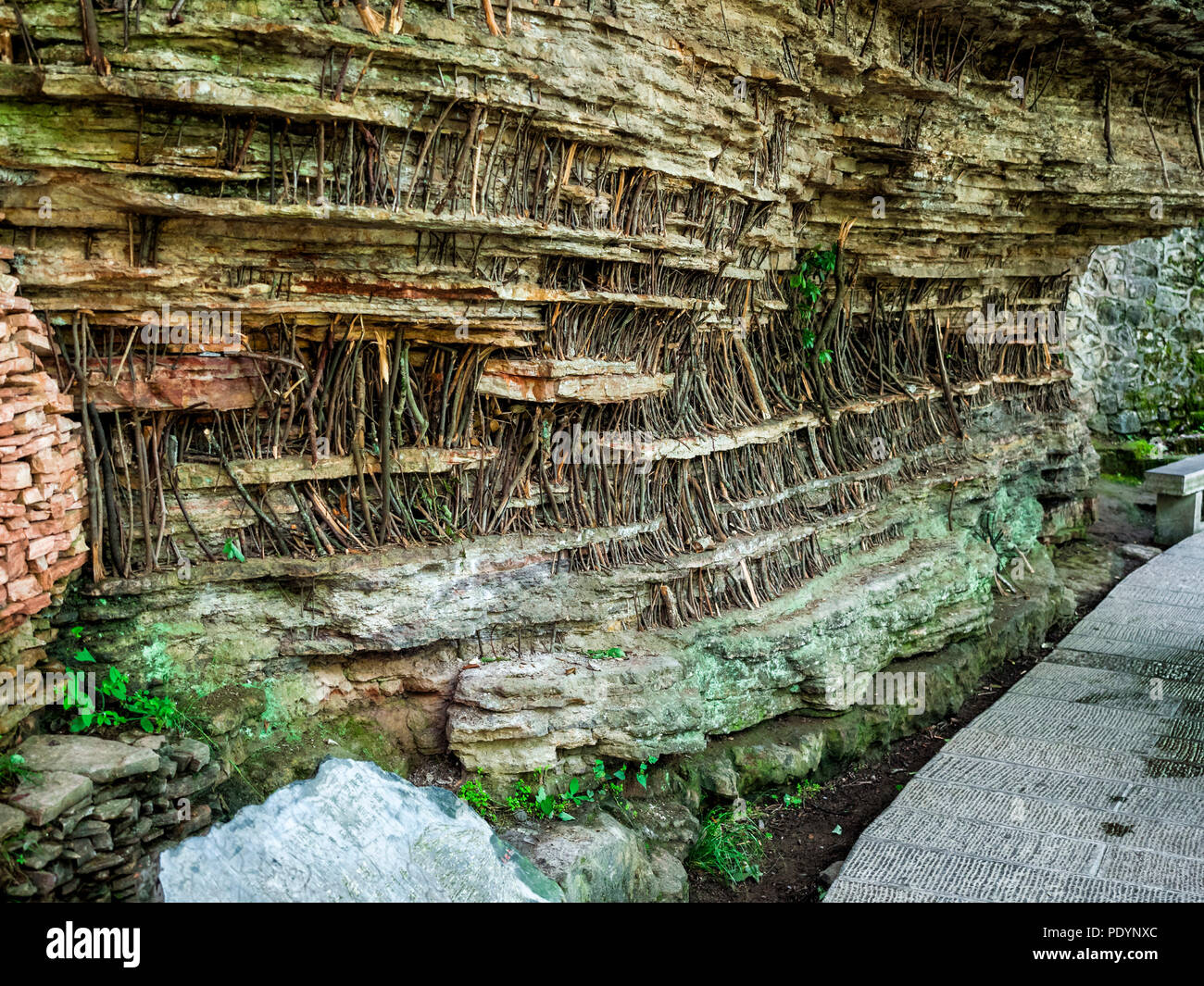 I bastoncini di legno immerso nelle fessure tra le rocce su una scogliera, una superstizione per sostenere la montagna con il significato di blesing. Un unico landsca Foto Stock