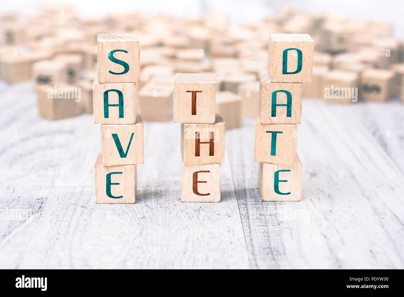 Le parole salvare la data formata da blocchi di legno su un tavolo bianco Foto Stock