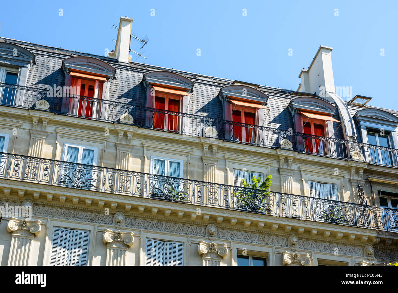 Vista dal basso la strada di un tipico parigino, opulento-cercando di edificio in stile haussmanniano con taglio facciata in pietra, ornamenti intagliati e balcone. Foto Stock