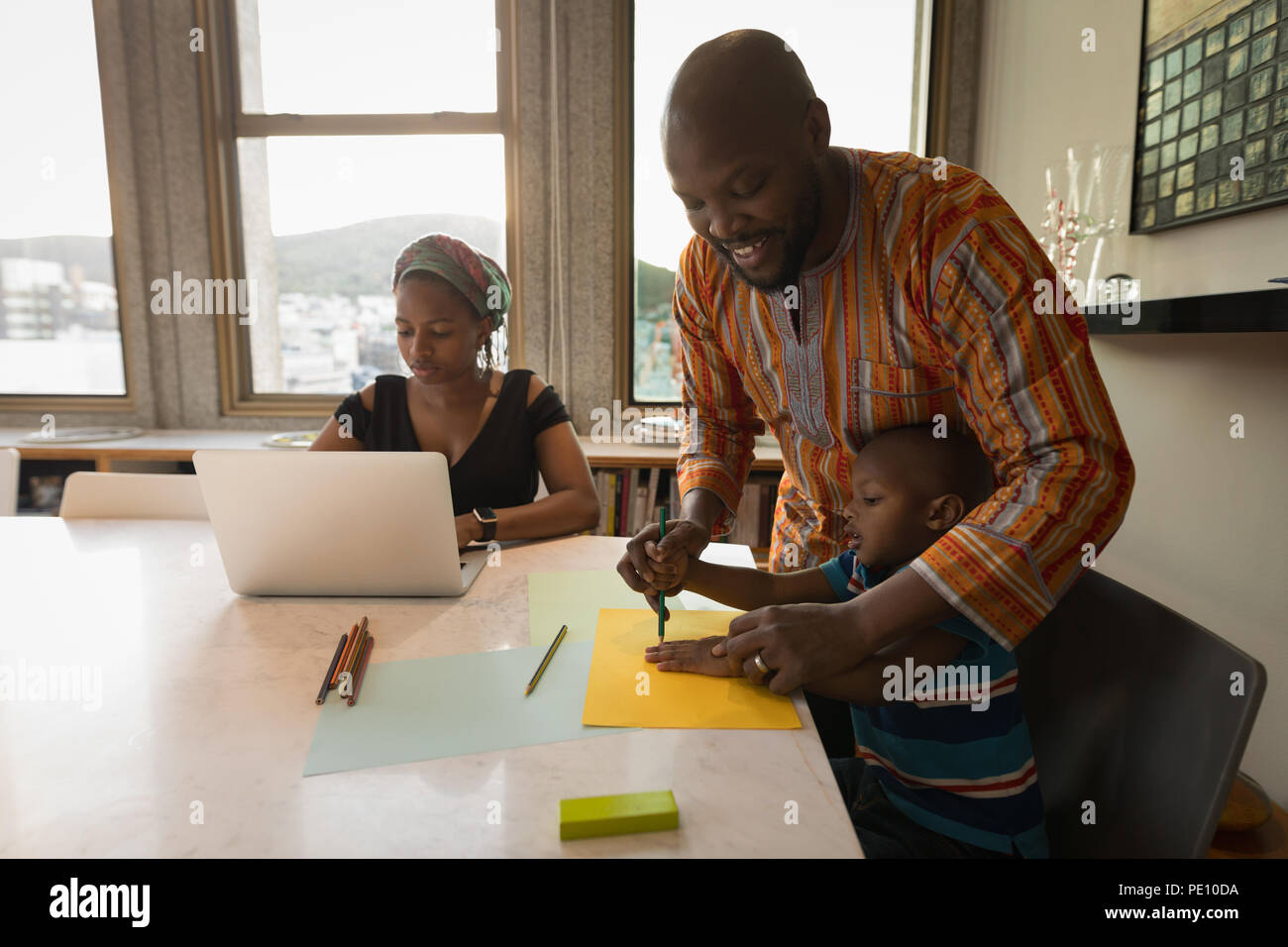 Padre che assiste il suo figlio per disegnare una bozza Foto Stock