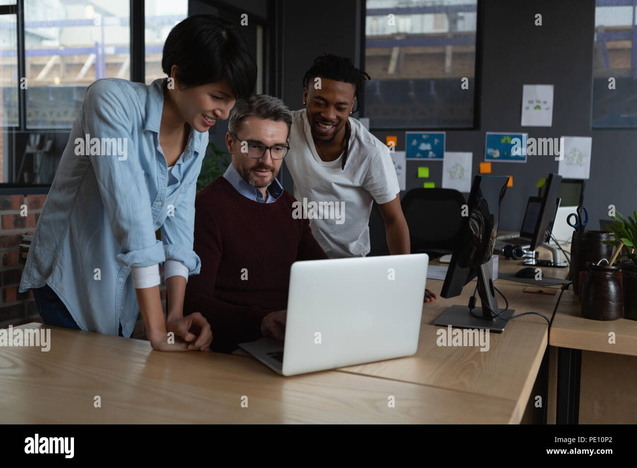 I dirigenti a discutere su computer portatile alla reception Foto Stock