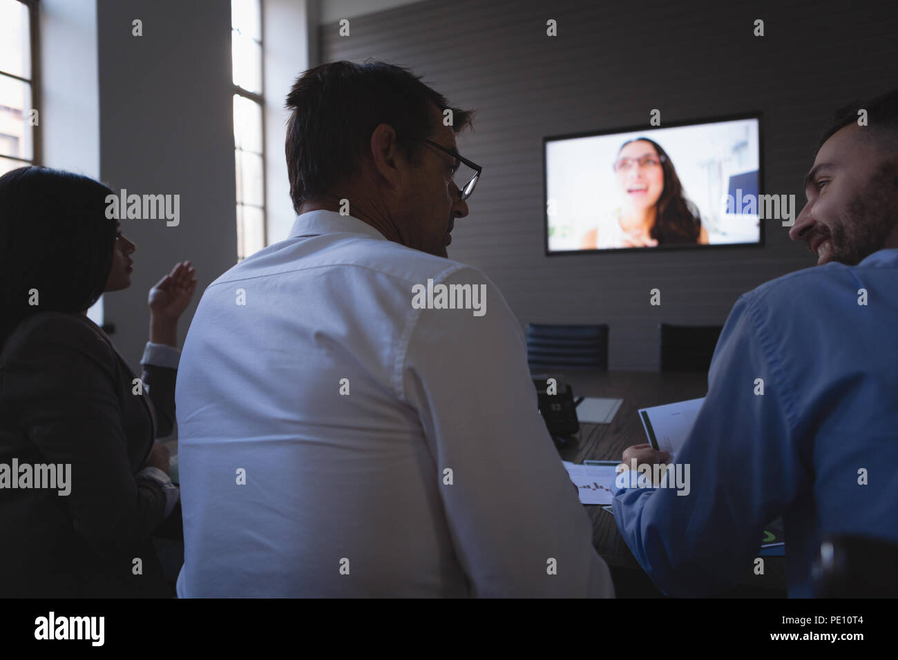 La gente di affari di conferencing con il collega su schermo lcd nella sala riunioni Foto Stock