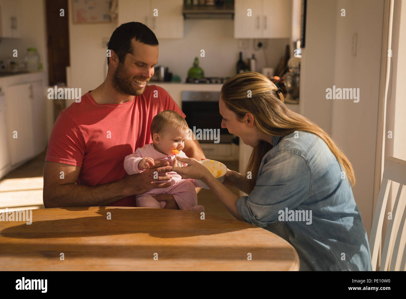 I genitori alimentando il loro bambino a casa Foto Stock