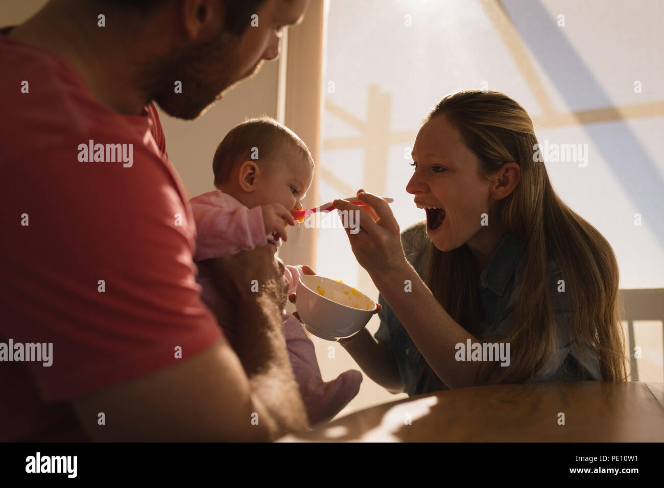 I genitori alimentando il loro bambino a casa Foto Stock