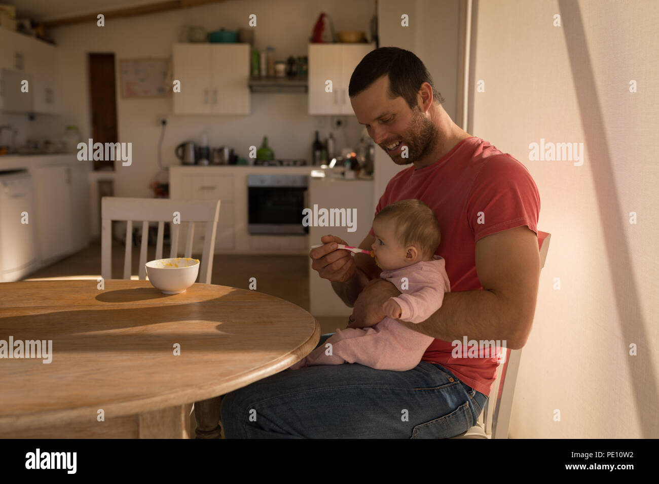 Padre alimentando il suo bambino con paletta Foto Stock