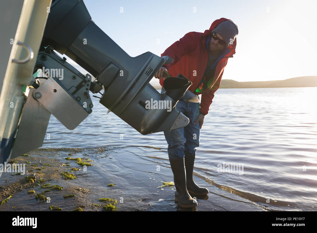 L'uomo controllo motoscafo vicino a lato del fiume Foto Stock