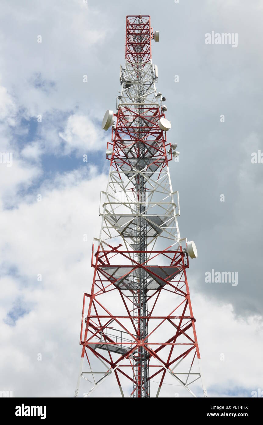 Cella di comunicazione torre contro il cielo nuvoloso Foto Stock