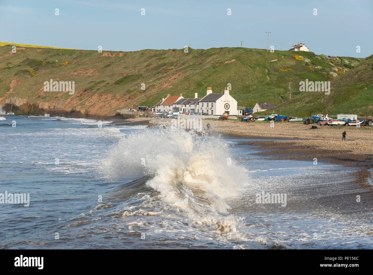 Grandi onde che si infrangono sulla spiaggia di cambs sulla costa del North Yorkshire, Inghilterra. Un bel pomeriggio di primavera. Foto Stock