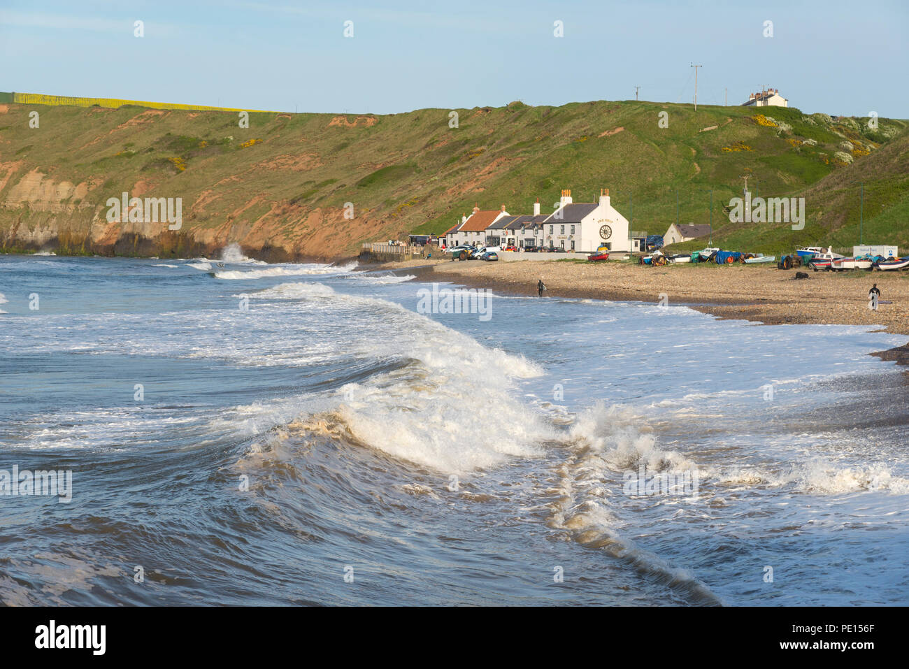 Grandi onde che si infrangono sulla spiaggia di cambs sulla costa del North Yorkshire, Inghilterra. Un bel pomeriggio di primavera. Foto Stock