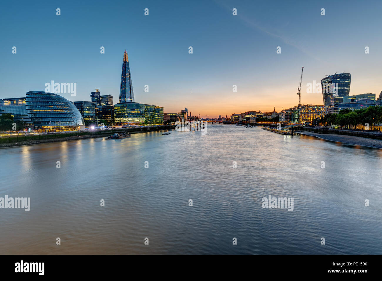 Vista del fiume Tamigi a Londra dopo il tramonto con i grattacieli della città e la torre Foto Stock