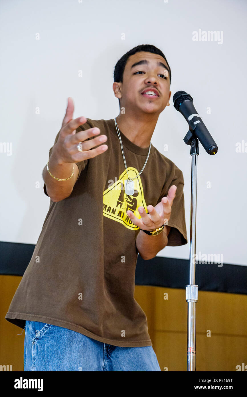 Miami Beach Florida, Public Library Youth Poetry Slam esegue performance, teen teenager ragazzo nero che parla male scena microfono utilizzando gesti della mano Foto Stock