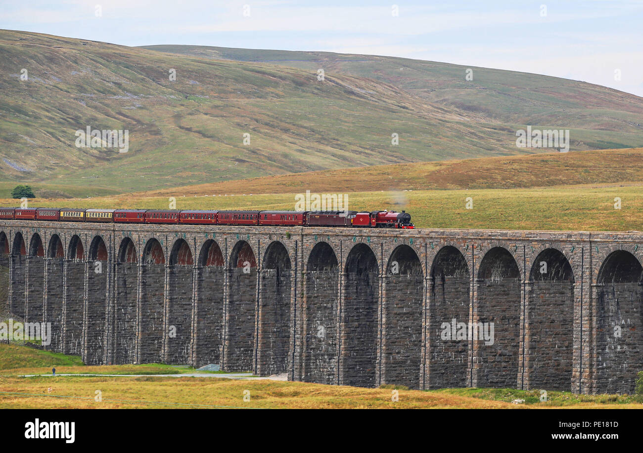 La montagna di pennini Express, tirato da uno storico locomotiva a vapore n. 45699 Galatea, attraversa il viadotto Ribblehead nel North Yorkshire come gli appassionati di ferroviaria occasione del cinquantesimo anniversario della fine della mainline regolari servizi vapore. Foto Stock