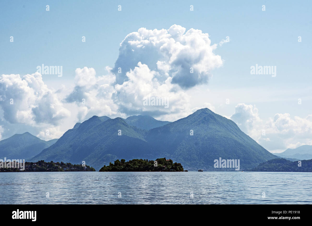 Vista del lago Maggiore da Baveno con Isola Madre e le montagne al di là. Cumulus nuvole e cielo blu. Foto Stock