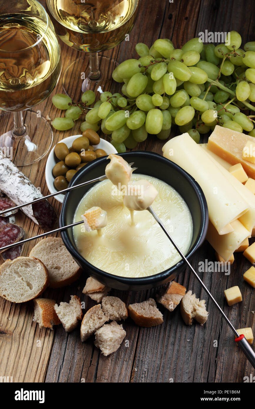 Gourmet fonduta svizzera cena su una sera d'inverno con formaggi assortiti  su una scheda a