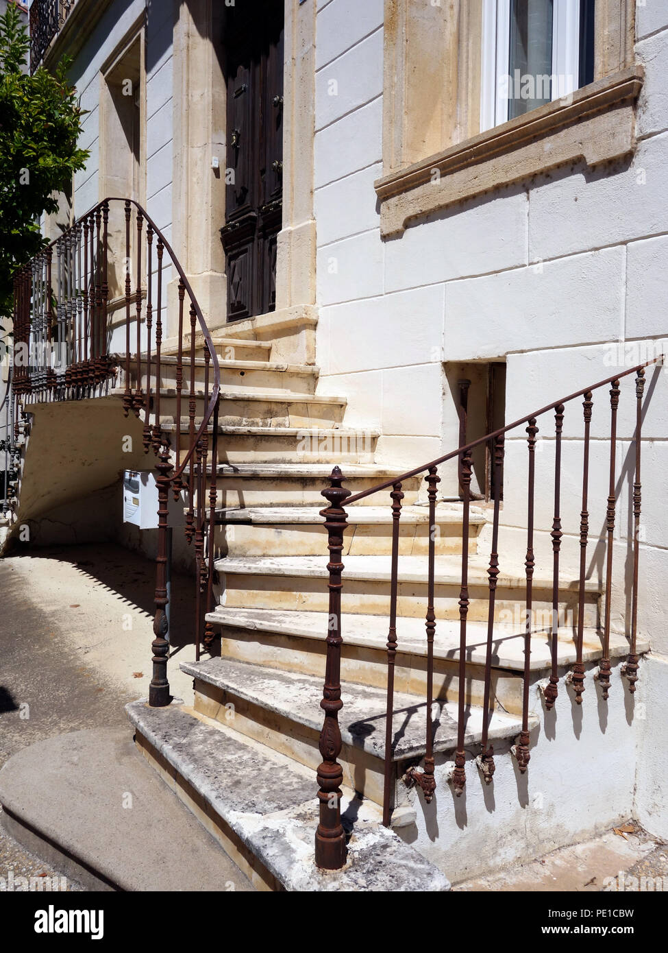 Piuttosto gradini che portano due modi fino alla porta anteriore esterno di un attraente casa francese in Cessenon-sur-Orb, Francia Foto Stock