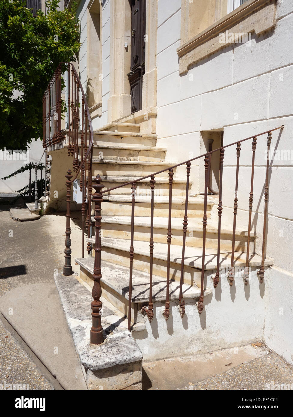 Piuttosto gradini che portano due modi fino alla porta anteriore esterno di un attraente casa francese in Cessenon-sur-Orb, Francia Foto Stock