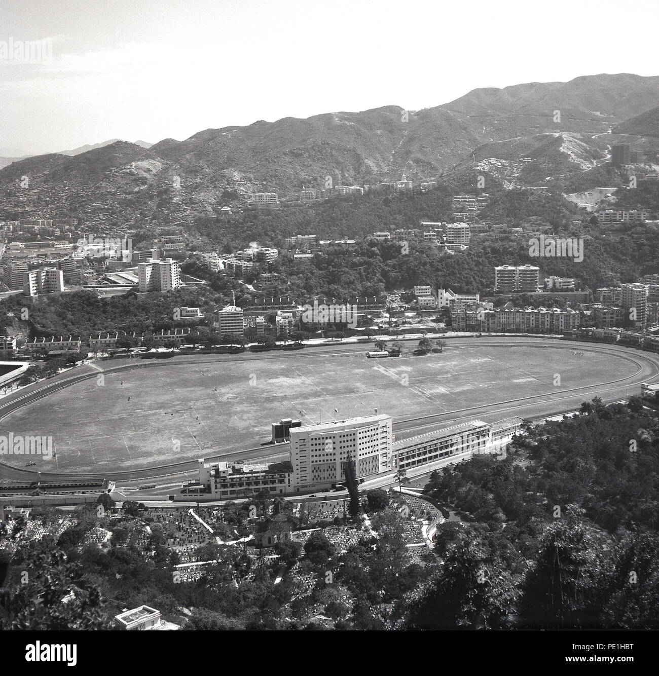 Degli anni Cinquanta, storico ariel vista dell'Ippodromo Happy Valley, di proprietà di Hong Kong Jockey Club di Hong Kong, fondato nel 1884 per fornire le corse di cavalli per British popoli che vivono sull'isola. In precedenza la terra di palude, era il solo terreno pianeggiante adatto per lo sport. Si può vedere che in questo momento, la zona circostante era scarsamente edificata su qualcosa che è cambiata radicalmente nel corso dei decenni seguenti con Hong Kong la rapida crescita economica. Foto Stock