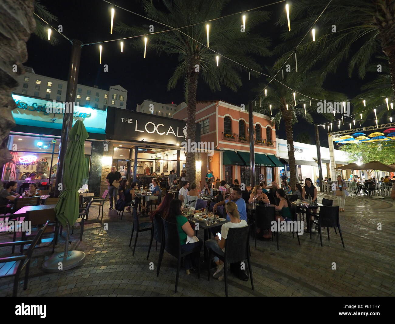 La Giralda Plaza e i suoi ristoranti e bar in Coral Gables, Florida, durante la notte, godendo della visitazione pesanti durante l'Ombrello Sky progetto. Foto Stock