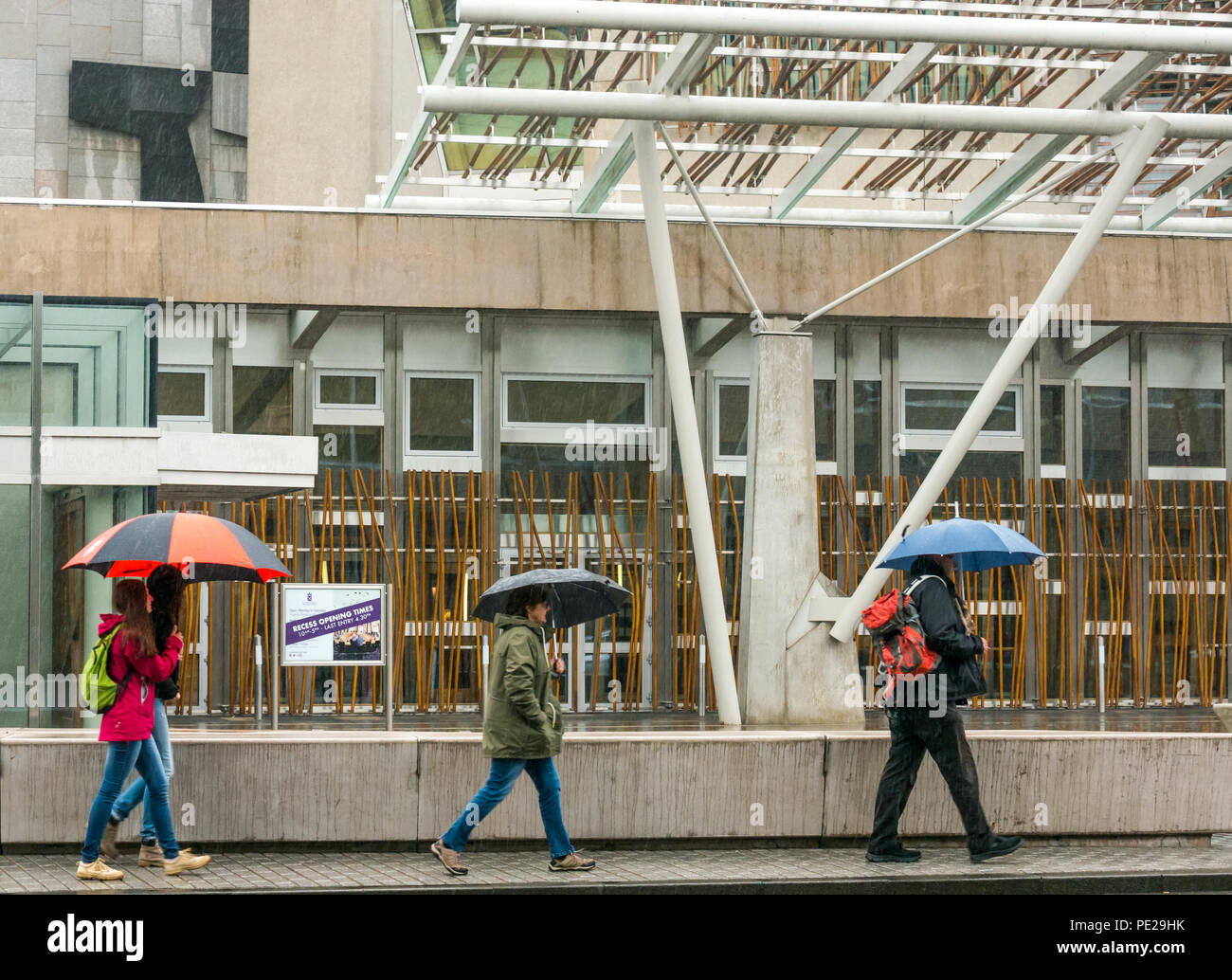 Holyrood, Edimburgo, Scozia, Regno Unito, 12 agosto 2018. Regno Unito: Meteo la pioggia e nebbia come i resti di tempesta Debby colpisce il capitale non scoraggiare i turisti all'edificio del parlamento scozzese. La gente che camminava ombrelli azienda Foto Stock