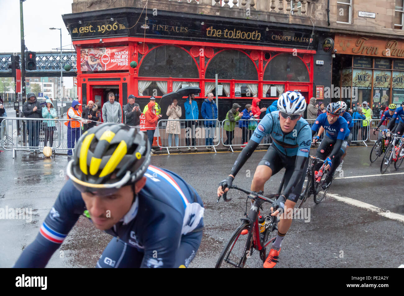 Glasgow, Scotland, Regno Unito. 12 Agosto, 2018. Il peloton negozia l'angolo del Saltmarket e Trongate durante l'uomo Escursioni in bicicletta da corsa su strada copertura 16 giri e 230 km attraverso le strade della città il giorno undici dei Campionati Europei Glasgow 2018. Credito: Berretto Alamy/Live News Foto Stock