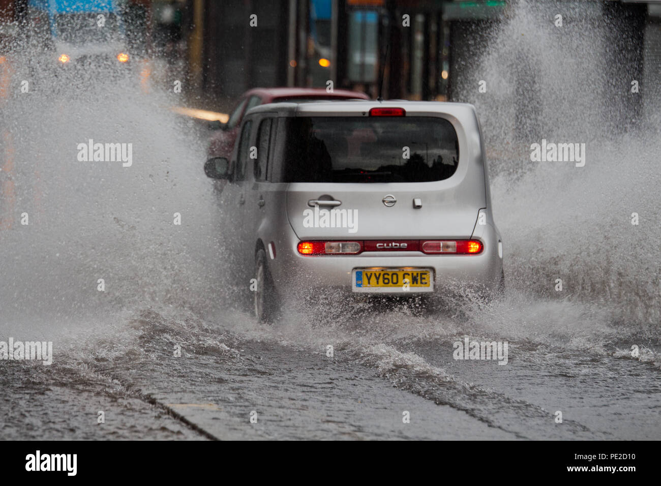 Liverpool, Regno Unito. 12 Agosto, 2018. Regno Unito Meteo. Auto drive through inondazioni su Smithdown Rd in Liverpool 15 dopo le piogge torrenziali hanno allagato la strada. Credito: Ken Biggs/Alamy Live News. Foto Stock