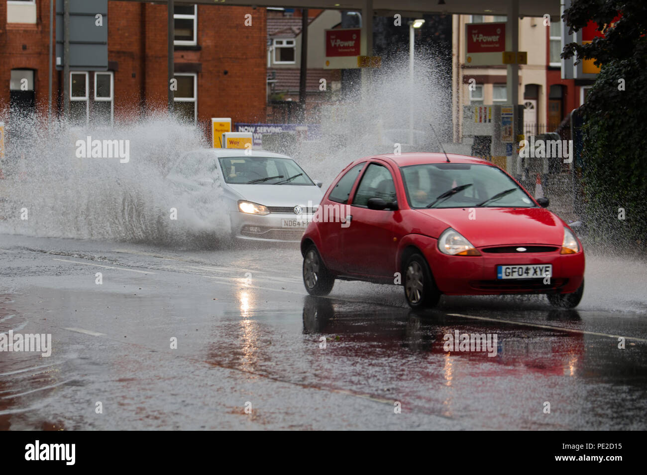 Liverpool, Regno Unito. 12 Agosto, 2018. Regno Unito Meteo. Auto drive through inondazioni su Smithdown Rd in Liverpool 15 dopo le piogge torrenziali hanno allagato la strada. Credito: Ken Biggs/Alamy Live News. Foto Stock