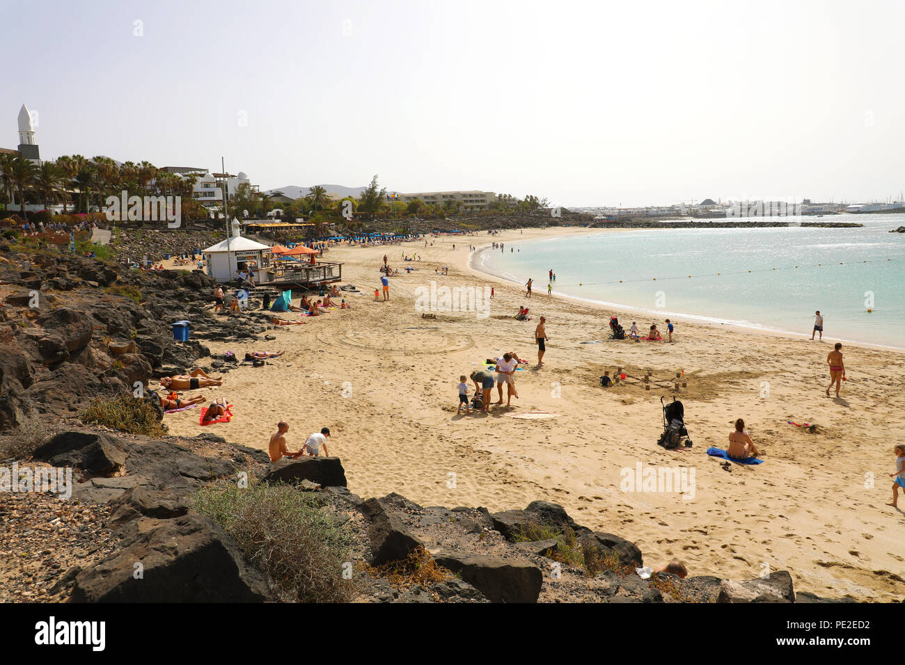 LANZAROTE, Spagna - 18 Aprile 2018: la splendida vista di Playa Dorada Beach con i bagnanti sulla sabbia, Lanzarote, Isole Canarie Foto Stock