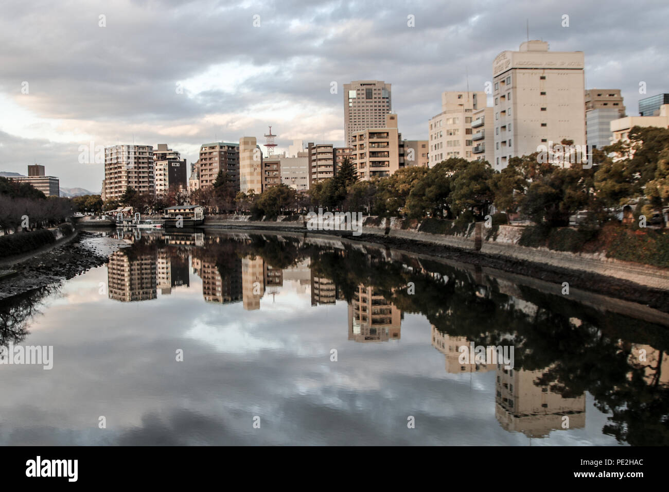 Il Fiume Motoyasu, visto dal ponte Heiwao, che fluisce oltre l'Hiroshima Parco del Memoriale della Pace di Hiroshima, Giappone. Foto Stock