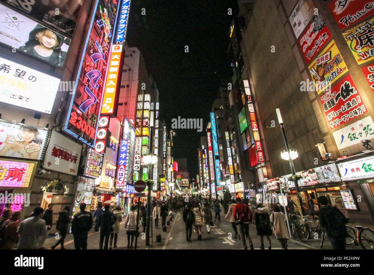 La gente a piedi attraverso una luce al neon illumina la strada dello shopping di Shinjuku sulla sera di Natale a Tokyo. Foto Stock