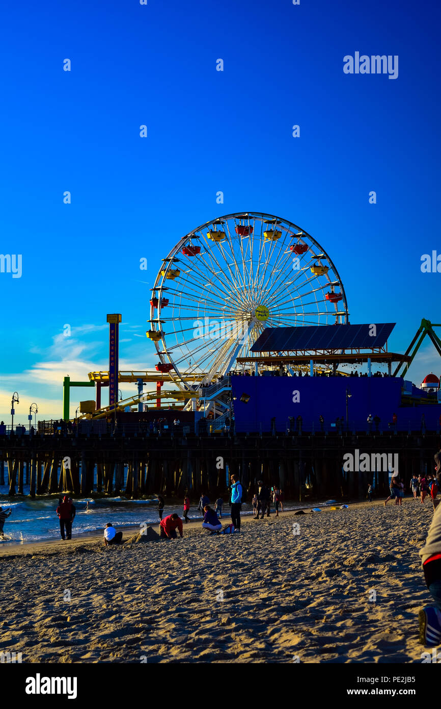 Le persone che si godono gli ultimi minuti prima del tramonto sulla spiaggia di Santa Monica, California con il molo in background Foto Stock