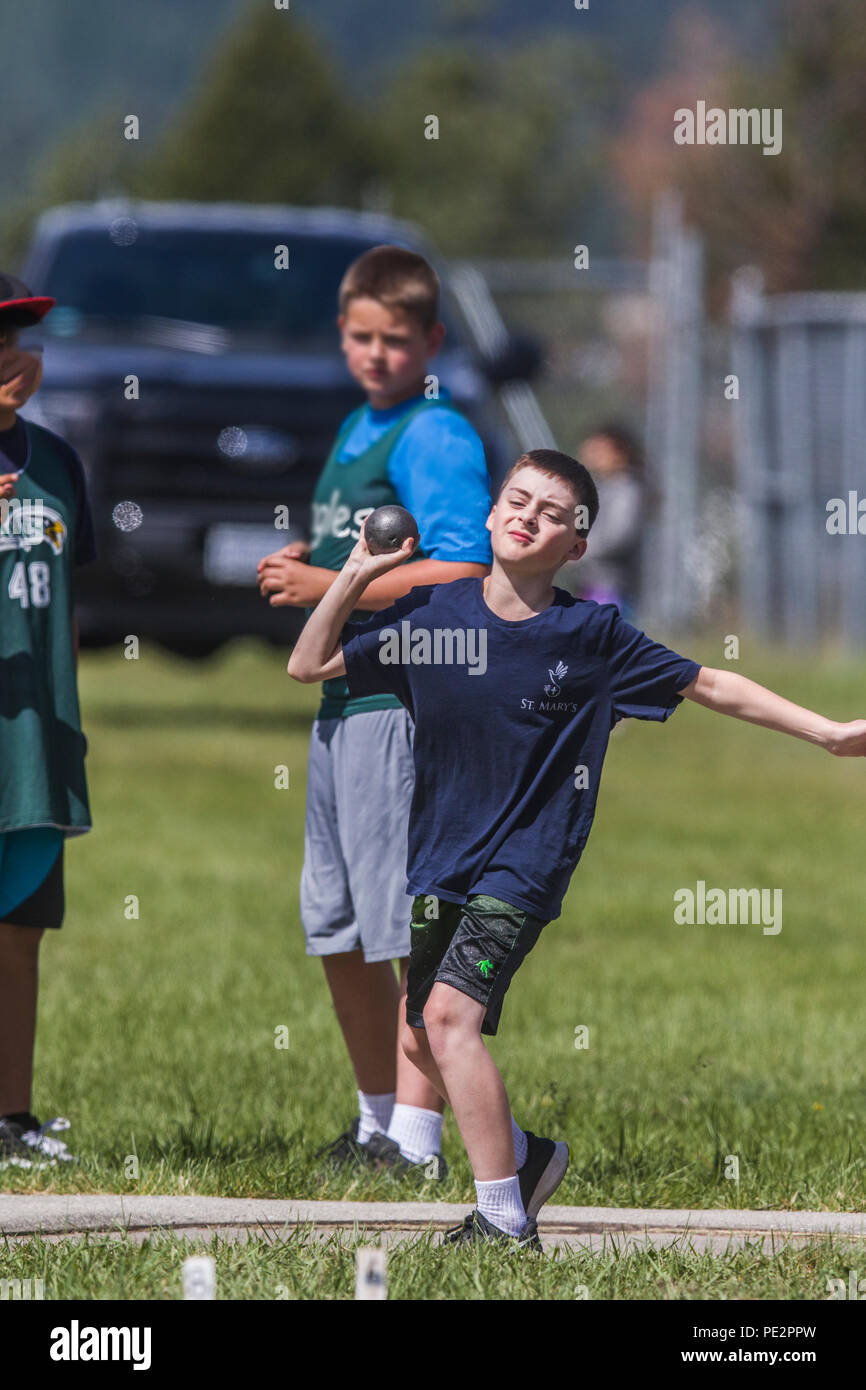 Giovane ragazzo in competizione in Track & Field di colpo messo. Indossare la T-shirt e pantaloncini, ottenendo set di relese colpo messo. Modello rilasciato. Foto Stock