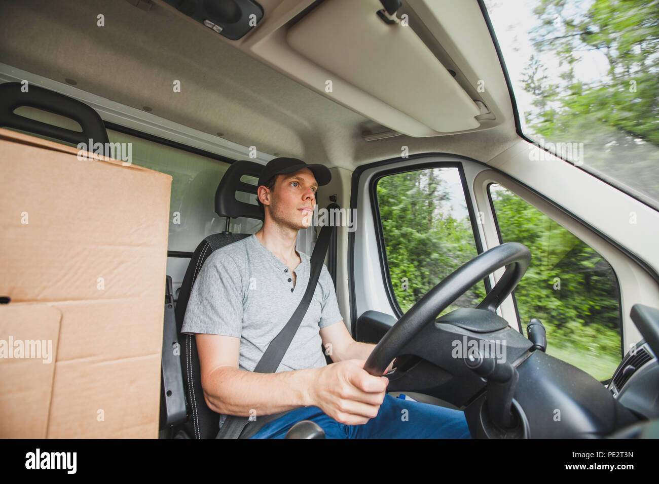 Autista uomo alla guida carrello consegna veicolo auto, il servizio di erogazione di pacchetti, cargo trasporto lavoro occupazione Foto Stock