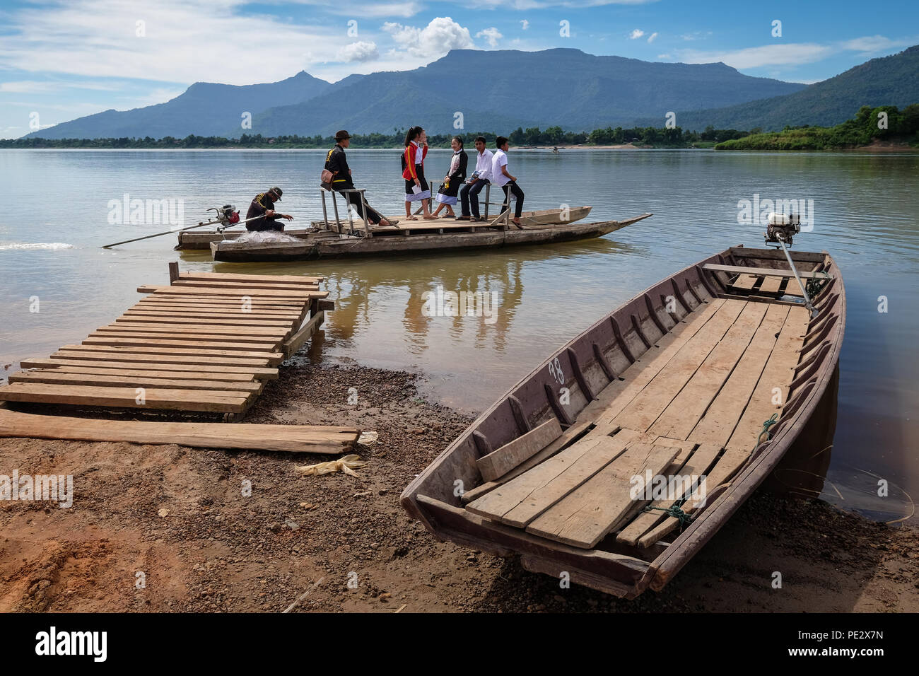 Un gruppo di studenti usando un di legno con il traghetto il fiume Mekong al Muang vicino Champasak, Paksè, in Laos Foto Stock