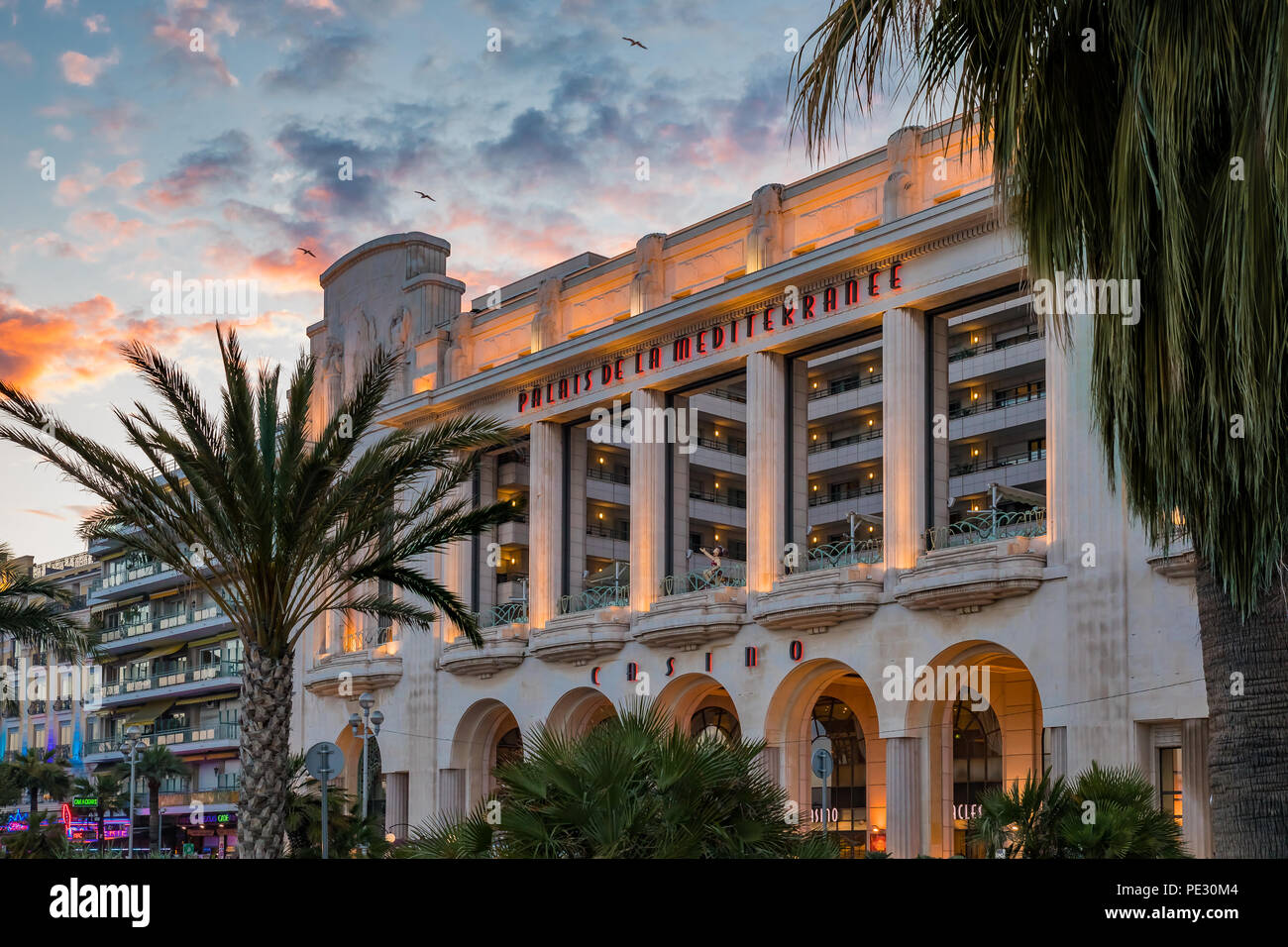 Nizza, Francia - 23 Maggio 2018: alberi di palma e il famoso Palais de la Mediterranee Art Deco hotel e casino da Hyatt sulla Promenade des Anglais in su Foto Stock