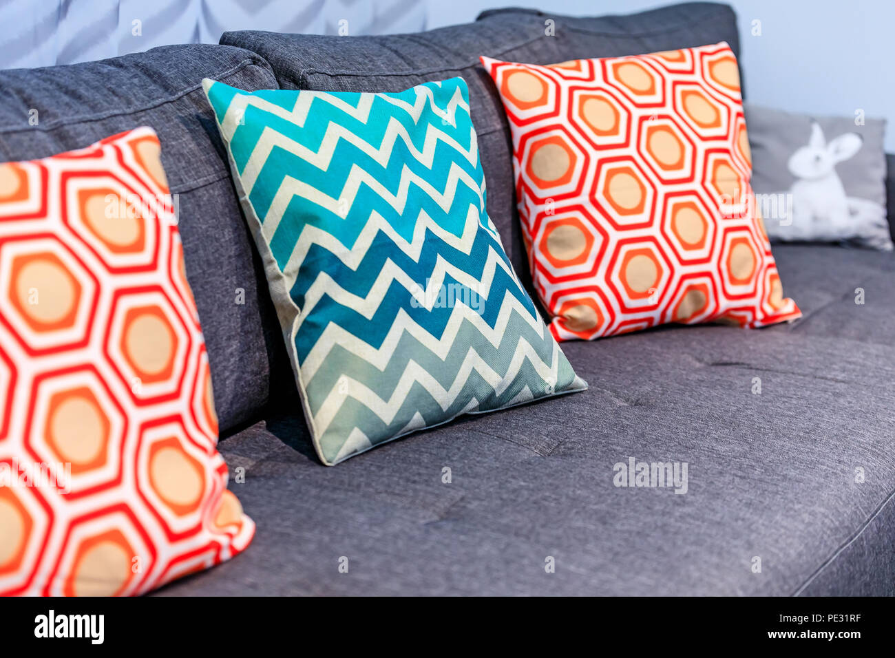 Close up di un lusso confortevole lettino con cuscini decorativi a motivi  geometrici e un simpatico coniglietto cuscino Foto stock - Alamy