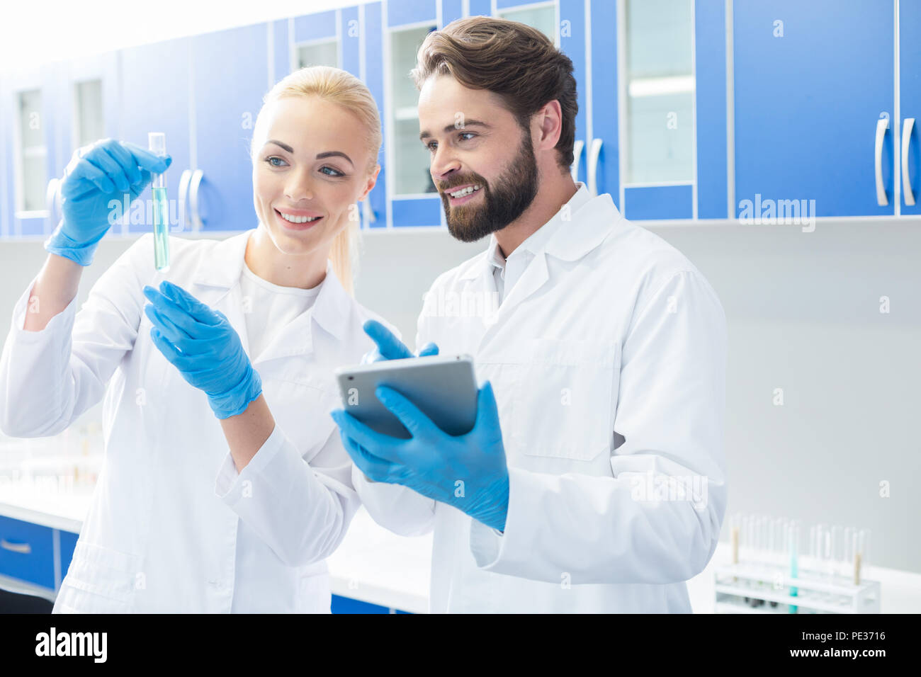 Progetto di successo. Allegro positivo biologi nizza assieme in laboratorio e sorridente pur essendo felice circa il loro progetto di successo Foto Stock