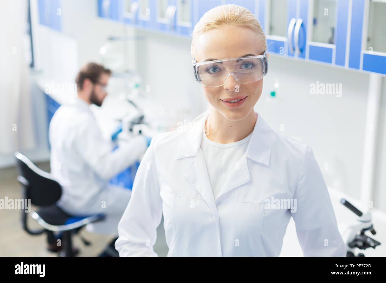 Lavoro preferito. Gioiosa nice professional farmacia sorridente e guardando a voi mentre sono felice circa il suo lavoro Foto Stock