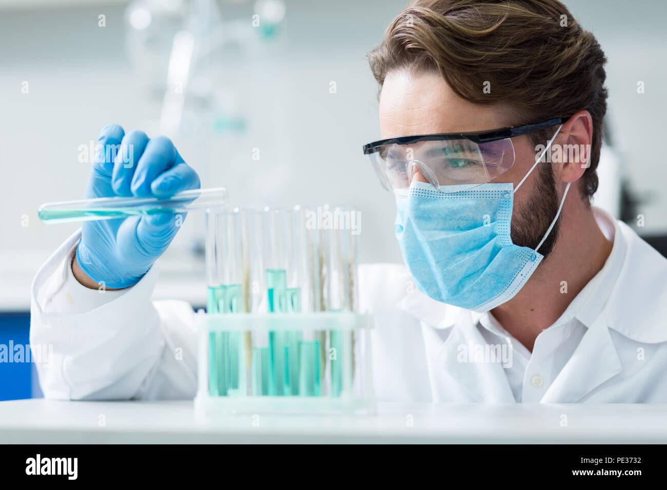 Professional farmacia. Smart nizza ricercatore maschio di indossare una  maschera e occhiali protettivi durante la conduzione di esperimento di  chimica in laboratorio Foto stock - Alamy