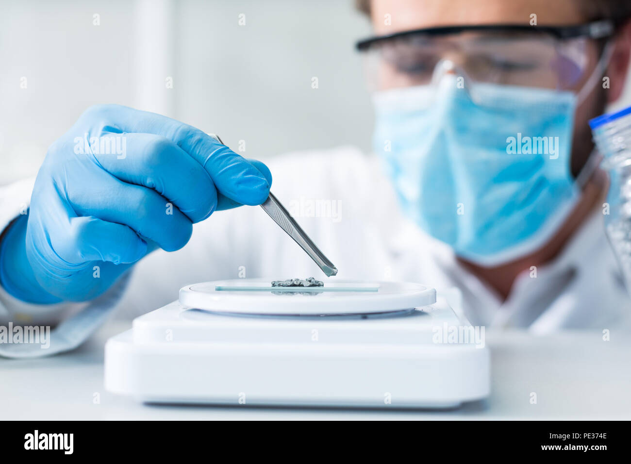 Analisi di laboratorio. Messa a fuoco selettiva delle pinzette a molla essendo utilizzato per il prelievo di campioni per analisi di laboratorio Foto Stock