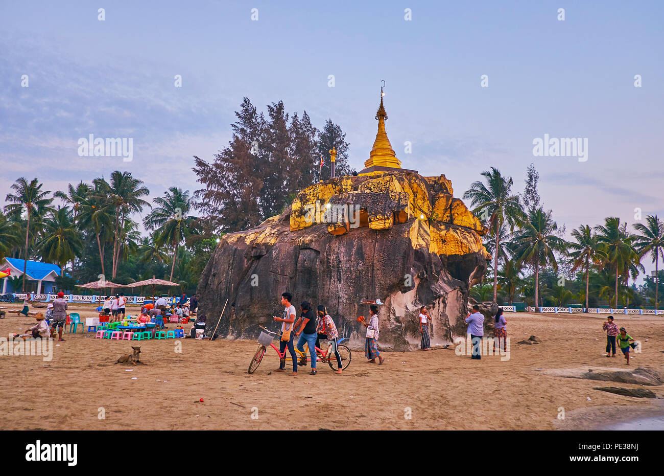 CHAUNG THA, MYANMAR - 28 febbraio 2018: il grande masso sulla costa del Golfo del Bengala viene rabboccato con stupa dorato di Kyauk Pa Pagoda Hto, nel febbraio Foto Stock