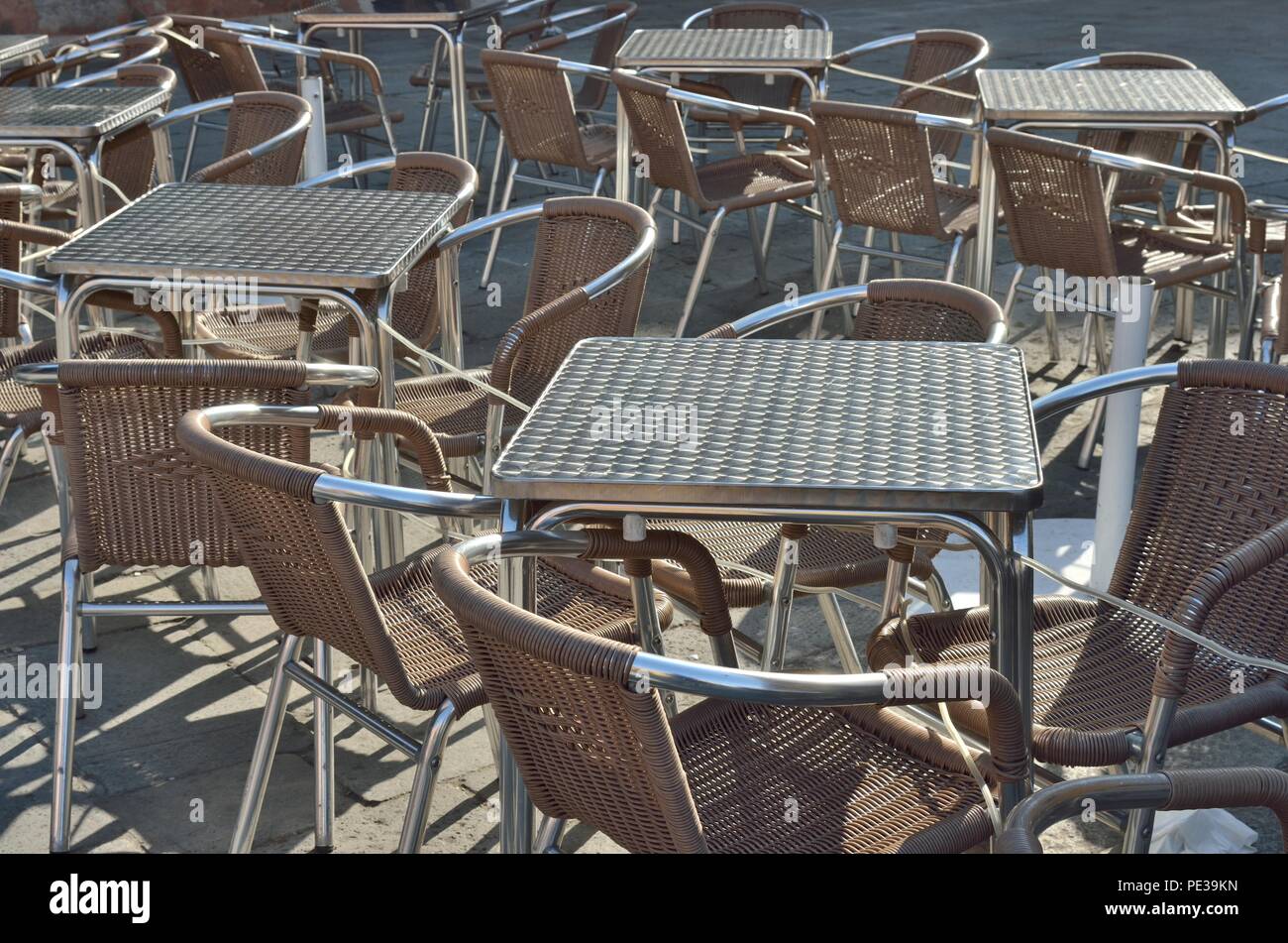 Una bella composizione di un gruppo di tavolini e sedie a forma quadrata, non occupato, a San Marcos - Piazza San Marco, Venezia, Italia, Europa Foto Stock