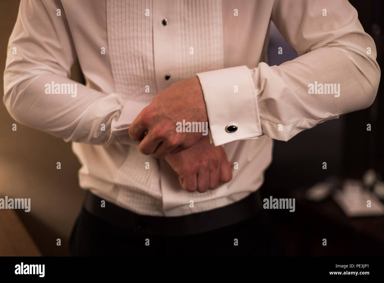 Uomo in camicia facendo fino gemelli. Foto Stock