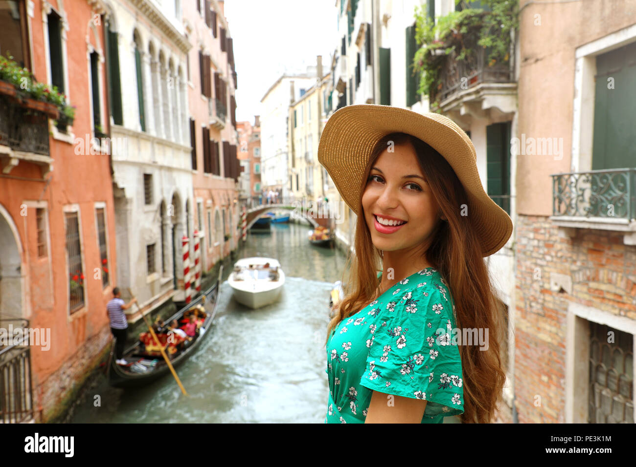 Sorridente Allegra donna con cappello e abito verde nella sua vacanza  veneziana. Felice affascinante ragazza sorriso alla telecamera a Venezia,  Italia Foto stock - Alamy